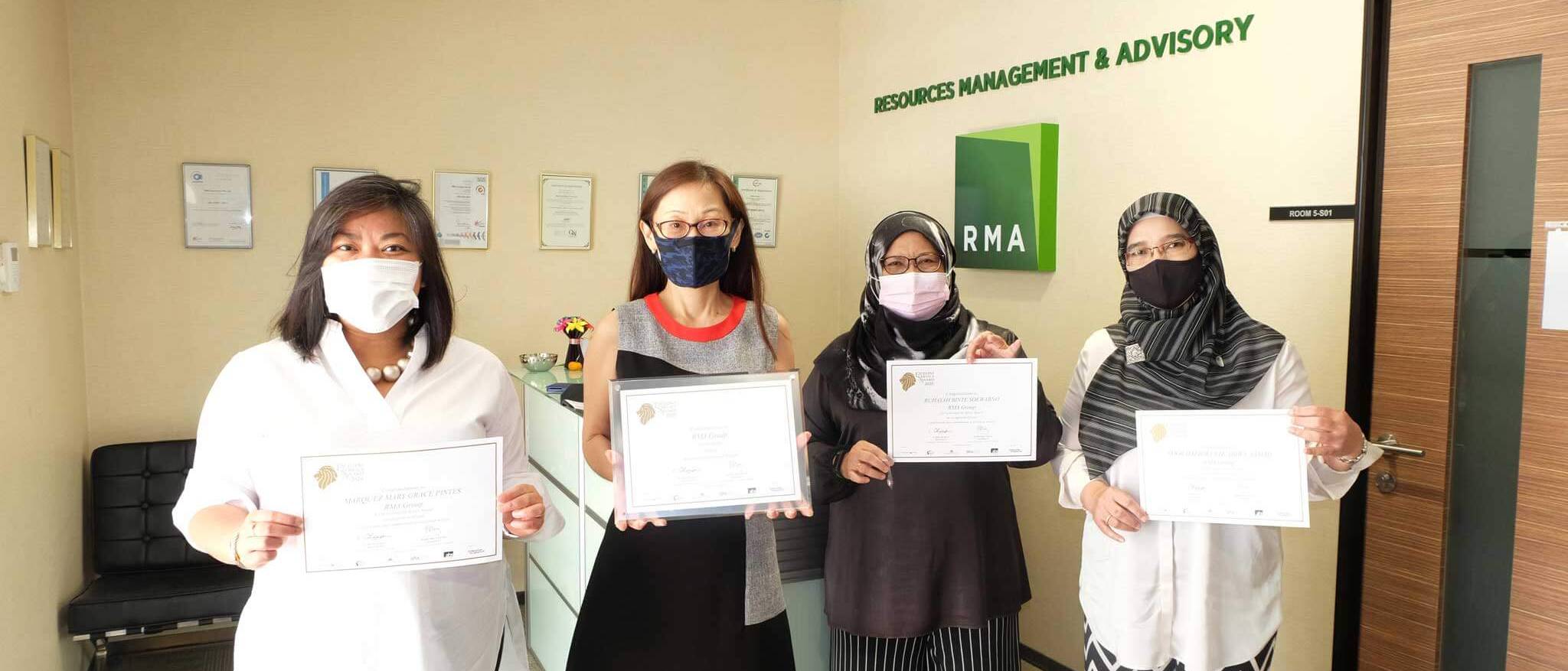 RMA staff holding Excellent Service Award certificates